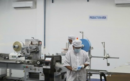 <p><strong>PRODUCTION AREA</strong>. A worker checks on the quality of SafeTech face mask produced by ModulHaus Inc., a local manufacturer and distributor of surgical face mask in the region in this undated photo. The DOST assisted the company in bringing the right technology for the mass production of quality face mask at a competitive price. (<em>Photo courtesy of DTI Region 1</em>) </p>