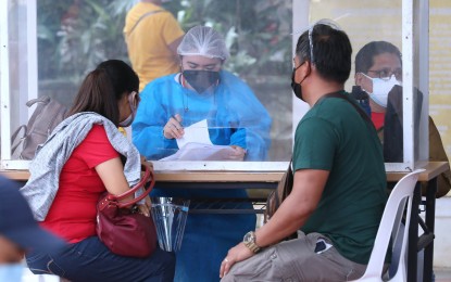<p><strong>BOOSTER SHOT SIGN-UP.</strong> A medical health worker checks the documents presented by residents availing of booster shots at the Batangas City capitol compound on Thursday (Nov. 25, 2021). The government is eyeing to inoculate nine million Filipinos during the national vaccination drive on November 29 to December 1. <em>(PNA photo by Joey O. Razon)</em></p>