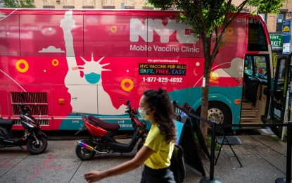 <p>A pedestrian passes a mobile vaccine clinic in the Brooklyn borough of New York, United States on Aug. 23, 2021. <em>(Photo by Michael Nagle/Xinhua)</em></p>