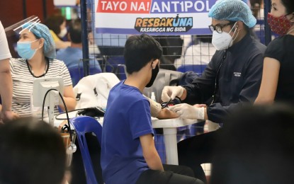 <p><strong>NAT'L VAX DAY.</strong> A teen gets his vital signs checked before receiving his Covid-19 vaccine at a mall in Antipolo City on Monday (Nov. 29, 2021), the first day of Bayanihan, Bakunahan national vaccination campaign. At least 51,375 individuals have been vaccinated against Covid-19 as of Monday morning.<em> (PNA photo by Robert Alfiler)</em></p>