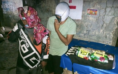 <p><strong>STERN WARNING.</strong> Suspects Vinch Neil Arnaiz (left), 27, and Jessie Llanos Caballero, 27, cover their faces after their arrest on C. Padilla St., Barangay Duljo-Fatima, Cebu City on Sunday night (Nov. 28, 2021). Cebu City Police Office Director Col. Josefino Ligan on Monday (Nov. 29) reiterated his stern warning to drug personalities of being arrested or killed if they would not stop their illegal activities. <em>(Photo courtesy of Eric Amaro)</em></p>
