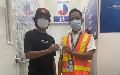 <p><strong>HONEST WORKER</strong>. Rio Billiones (right), a utility worker at a mall in Tuguegarao City, is shown returning the P35,900 cash he found while doing his duty on Tuesday (Nov. 30, 2021). John Carlo Cabbuag (left), the owner of the money, said his brother was supposed to deposit the amount at a bank when he accidentally dropped it. <em>(Photo courtesy of SM Downtown/Gerina Malubay-Torno)</em></p>