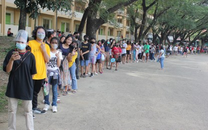 <p><strong>YOUNG VACCINEES.</strong> Some teenagers are accompanied by their parents and guards line up to get their first dose of Pfizer Covid-19 vaccine during the last day of the ”Bayanihan, Bakunahan” vaccination drive at The Tent, DIHS (former DNHS Main High School), Barangay Burol 1, City of Dasmarinas, Cavite on Dec. 1, 2021. The city government has provided an additional vaccination site for minors aged 12 to 17 years old walk-in vaccinees.<em> (PNA photo by Gil Calinga)</em></p>