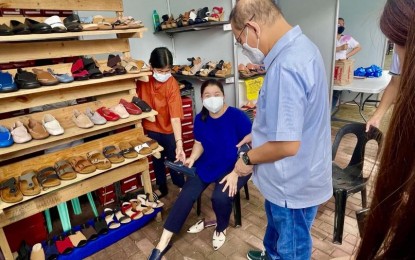 <p><strong>SHOE BAZAAR.</strong> Marikina Mayor Marcy Teodoro and his wife, Maan shop for shoes at the opening of the city's Christmas Shoe Bazaar, in front of the City Hall on Monday (Dec. 6, 2021). The bazaar was opened amid the pandemic to help craftsmen and shoemakers recover from the impact of the pandemic. <em>(Photo courtesy of Marikina LGU)</em></p>