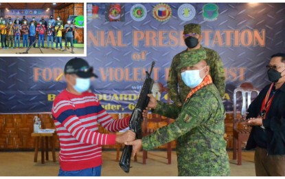 <p><strong>SURRENDER.</strong> One of the 14 surrendering BIFF gunmen hands over his rifle to Brig. Gen. Eduardo Gubat (center), 603rd Infantry Brigade commander, during surrender rites held at the 57th Infantry Battalion headquarters in Upi, Maguindanao on Sunday (Dec. 5, 2021). The surrenderers also turned over (inset upper left) 12 high-powered firearms and five explosives. <em>(Photo courtesy of 603rd IBde)</em></p>
