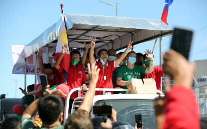 <p><strong>GRAND CARAVAN</strong>. Former Senator Ferdinand Marcos Jr. and presidential daughter Davao City Mayor Sara Z. Duterte wave to the crowd from their float during a grand caravan along Commonwealth Avenue in Quezon City on Wednesday (Dec. 8, 2021). On Tuesday, the Hugpong ng Pagbabago expressed elation over the latest PUBLiCUS Asia survey result showing the tandem emerging as the top picks for next year's polls.<strong><em> (File PNA photo by Joey O. Razon)</em></strong></p>
