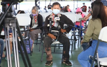 <p><strong>PANDEMIC'S IMPACT ON DRIVERS</strong>. Ricarte Floresca, 69, shares the challenges his family had to face at the height of Covid-19, in an interview at the BP2 depot in Quezon City on Monday (Dec. 6, 2021). A total of 43 individuals belonging to 11 families departed for La Union, Ilocos Sur, and Iloilo provinces on Dec. 7. (<em>PNA photo by Robert Oswald P. Alfiler</em>)</p>