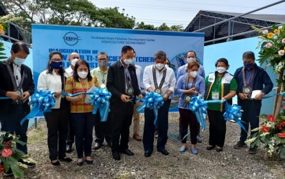 <p><strong>AQUACULTURE BOOST.</strong> Agriculture Secretary William Dar and Southeast Asian Fisheries Development Center Aquaculture Department (SEAFDEC/AQD) chief Dan Baliao (4th and 5th from left, respectively) cut the ribbon during the inauguration of the new broodstock and hatchery facilities in Tigbauan, Iloilo on Thursday (Dec. 9, 2021). The structures are expected to boost aquaculture production in the country. <em>(PNA photo by Pearl G. Lena)</em></p>