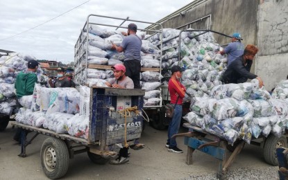 <p><strong>AMPLE SUPPLY.</strong> Vegetable farmers in Benguet prepare packs of vegetables at the La Trinidad vegetable trading area on Dec. 5, 2021. Atok town Mayor Raymundo Sarac on Friday (Dec. 10, 2021) said the frost that occurred in parts of the town due to the cold weather will not affect the supply and prices of vegetables from the Cordillera. <em>(PNA photo by Liza T. Agoot)</em></p>