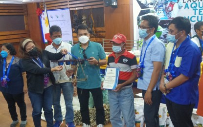 <p><strong>TURNOVER.</strong> Officials of the Department of Agriculture and the Bureau of Fisheries and Aquatic Resources turn over the technology business incubator project for oyster production to seven local government units in Pangasinan on Saturday (Dec. 11, 2021). The ceremony was held in Dagupan City. <em>(PNA photo by Hilda Austria)</em></p>