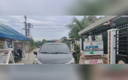 <p><strong>CHECKPOINT</strong>. A police officer checks a motorist’s travel documents at a border checkpoint in Rosales town in Pangasinan on Nov. 9, 2021. The province has eased its requirements for fully vaccinated travelers. <em>(Photo courtesy of Rosales Police)</em></p>