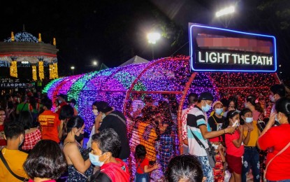 <p><strong>CHRISTMAS DISPLAY</strong>. A 40-foot neon-hued passageway dubbed the “Tunnel of Lights” in the middle of the Bacolod Public Plaza draws visitors for some photo opportunities on Monday (Dec. 13, 2021). Some 95,000 lights have been installed to turn the venue into a spectacle of the Yuletide season.<em> (Photo courtesy of Bacolod City PIO) </em></p>