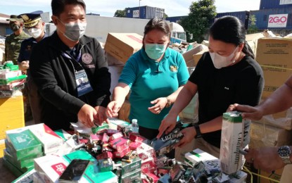 <p><strong>CIGARETTES DESTRUCTION.</strong> Segundo Sigmundfreud Barte Jr., Bureau of Customs-Zamboanga district collector (left), and Councilor Josephine Pareja (right) tear apart smuggled cigarettes, as part of the destruction Wednesday (Dec. 15, 2021). It is part of PHP300 million worth of confiscated cigarettes in Zamboanga City. <em>(Photo by: Teofilo P. Garcia, Jr.)</em></p>