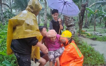 <p><strong>ODETTE'S ONSLAUGHT.</strong> Members of a rescue team help a senior citizen during the evacuation in Tubay, Agusan del Norte on Thursday (Dec. 16, 2021). Thousands of residents in the Caraga Region fled their homes as Typhoon Odette made its first landfall Thursday afternoon in Siargao Island, Surigao del Norte.<em> (Photo courtesy of BFP Tubay)</em></p>