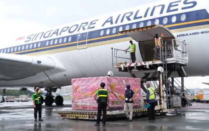 <p><strong>NEW DONATIONS.</strong> Singapore Airlines Flight SQ912 lands with 1,020,500 doses of the Moderna Covid-19 vaccine at the Ninoy Aquino International Airport Terminal 3 in Pasay City on a rainy Friday afternoon (Dec. 17, 2021). The jabs are donations from the German government through the COVAX Facility. <em>(Photo courtesy of NTF)</em></p>