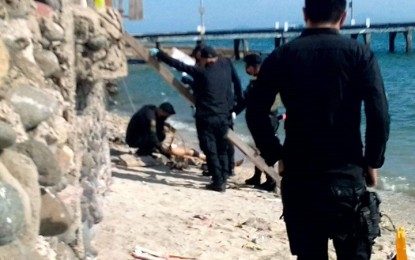 <p><strong>EXPLOSION.</strong> Policemen check the body of a certain Erickson, 12, who instantly died Monday (Dec. 20, 2021) in an explosion of a still unknown type of explosive along the shore of Barangay Rio Hondo, Zamboang City. A teenage companion of Erickson, a certain Jovan, was wounded during the incident. <em>(Photo courtesy of Remus Lim Ong)</em></p>