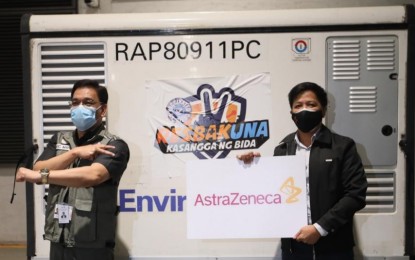 <p><strong>MILESTONE.</strong> NTF strategic communications on current operations head, Assistant Secretary Wilben Mayor (left), shows the Resbakuna sign during the arrival of 1,957,000 doses of AstraZeneca vaccine at the NAIA Terminal 3 on Sunday night (Dec. 26, 2021). The country has so far received a total of 200,885,005 Covid-19 vaccine doses. <em>(PNA photo by Avito Dalan)</em></p>