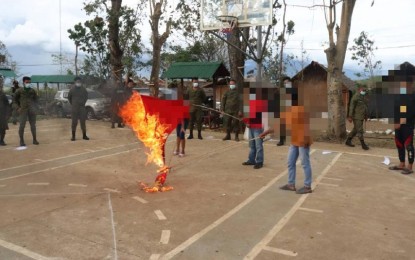 <p><strong>WITHDRAWAL OF SUPPORT.</strong> Former communist rebels from central Negros burn the Communist Party of the Philippines - New People’s Army flag during their surrender rites at the 62nd Infantry Battalion headquarters in Barangay Libas, Isabela, Negros Occidental on Sunday (Dec. 26, 2021). Eight rebels turned their backs on insurgency on the day the CPP marked its 53rd anniversary.<em> (Photo courtesy of 303rd IBde, Philippine Army)</em></p>