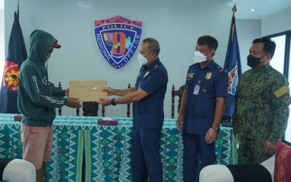 <p><strong>CASH REWARD.</strong> Police Regional Office-Zamboanga Peninsula (PRO-9) director Brig. Gen. Franco Simborio, during a ceremony at Camp Abendan in Barangay Mercedes on Tuesday (Dec. 28, 2021), hands over the cash reward to the informant who provided vital information that led to the arrest of three high-value drug suspects and confiscation of PHP6.8 million worth of shabu in Zamboanga City. The anti-drug operation was carried out last Sunday in Barangay Upper Calarian. <em>(Photo courtesy of PRO-9)</em></p>
