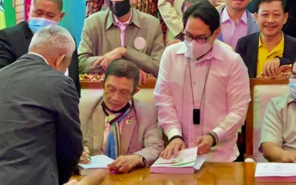<p><strong>BARMM BUDGET.</strong> Bangsamoro Parliament Speaker Pangalian Balindong (seated, left) signs their 2022 budget of PHP79.8 billion after it was approved on third and final reading by the Bangsamoro Transition Authority (BTA) of the Bangsamoro Region in Muslim Mindanao (BARMM) on Tuesday (Dec. 28, 2021). Other parliament members look on during the signing ceremony. <em>(Photo courtesy of BARMM Member of Parliament Susana Anayatin)</em></p>