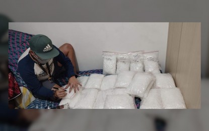 <p><strong>BIG HAUL.</strong> A PDEA agent accounts for packs of shabu seized during a buy-bust operation in Mandaluyong City on Monday (Dec. 27, 2021). Authorities seized PHP534 million worth of shabu from suspects Mike Abac and Edison de Guzman. <em>(Photo courtesy of PDEA)</em></p>