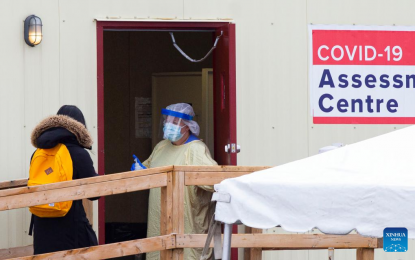 <p>A medical worker holds a door open for a woman at the entrance of a COVID-19 assessment center in Toronto, Canada, on Dec. 28, 2021. Canada reported 22,219 new COVID-19 cases Tuesday noon, raising the cumulative whole to 2,057,489 cases with 30,199 deaths, according to CTV.<em> (Photo by Zou Zheng/Xinhua)</em></p>