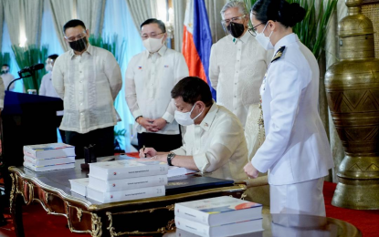 <p><strong>2022 NAT’L BUDGET.</strong> President Rodrigo Roa Duterte signs the P5-trillion 2022 national budget during the signing ceremony at the Malacañan Palace on Thursday (Dec. 30, 2021). Next year’s budget is higher by 11.5 percent than this year’s PHP4.5 trillion national budget.<em> (Presidential photo by King Rodriguez)</em></p>