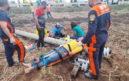 <p><strong>INJURED</strong>. Emergency responders provide first aid treatment to the two linemen who were injured when the electric pole they were erecting collapsed in Hinigaran, Negros Occidental on Wednesday afternoon (Dec. 29, 2021). On Thursday (Dec. 30), the two were reported already recuperating in a hospital. <em>(Photo courtesy of Bureau of Fire Protection-Hinigaran, Negros Occidental)</em></p>