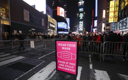 <p><strong>PRECAUTION.</strong> A sign reminds the wearing of masks during the New Year celebrations at Times Square in New York City on Dec. 31, 2021. The United States shattered daily Covid-19 cases record as over 580,000 daily cases were recorded nationwide on Thursday. <em>(Xinhua/Wang Ying)</em></p>