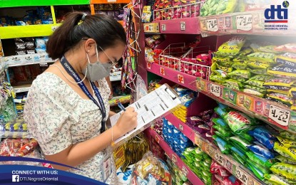 <p><strong>PRICE MONITORING</strong>. A Department of Trade and Industry (DTI) staff checks on the prices of commodities at a grocery store in Dumaguete City in this Dec. 21, 2021 photo. The DTI-Negros Oriental has reassured there is no hoarding or shortage of supplies in the aftermath of Typhoon Odette which hit the province on Dec. 16, 2021.<em> (Photo from the Facebook page of DTI-Negros Oriental)</em></p>