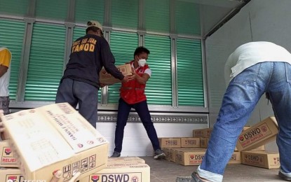<p><strong>FAMILY FOOD PACKS</strong>. Department of Social Welfare and Development (DSWD) personnel at the repacking and preposition site in Dumarao, Capiz carry family food packs (FFPs) for transport to Dao in Capiz and Negros Occidental on Tuesday (Jan. 4, 2022). As of 5 p.m. of January 3, DSWD has already provided PHP37.066 million worth of assistance.<em> (Photo courtesy of Arnulfo Leal/DSWD 6)</em></p>