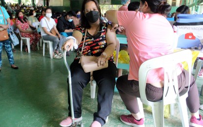 <p><strong>ADDED PROTECTION.</strong> Micah Martinez, who is afflicted with the motor disability disease cerebral palsy, avails of a Moderna Covid-19 booster shot at the Dasmariñas II Central Elementary School in Cavite on Tuesday (Jan. 4, 2022). The booster shot is timely as the province is placed under Alert Level 3, along with Bulacan, Rizal, and Metro Manila, due to rising infections.<em> (PNA photo by Gil Calinga)</em></p>