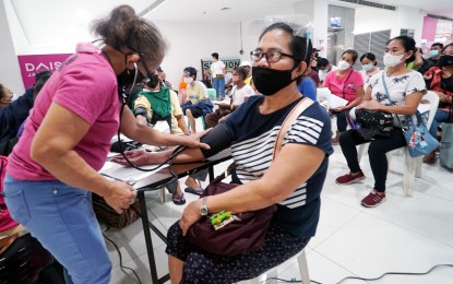 <p><strong>PRE-JAB.</strong> A health worker checks the blood pressure of a senior citizen at the screening area of a mall vaccination site along Quirino Highway in Caloocan City on Friday (Jan. 7, 2022). Health authorities continuously remind that getting vaccinated is the best protection against Covid-19. <em>(PNA photo by Ben Briones)</em></p>
