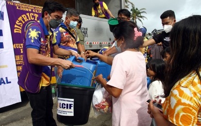 <p><strong>CONTINUOUS EFFORTS.</strong> Charles Darwin Javellana (left), governor of Lions Club International District 301E in Mindanao, leads the distribution of food packs to more than 100 Typhoon Odette-affected residents in Barangay Sabang, Surigao City on Saturday (Jan. 8, 2022). The distribution activity that ended Sunday (January 9) also gave away 600 water containers and 365 gallons of potable water to three other villages. <em>(PNA photo by Alexander Lopez)</em></p>