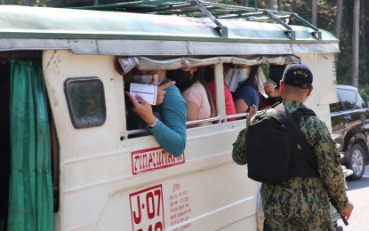 <p><strong>STRICT MEASURE</strong>. A police officer asks passengers of a utility public vehicle in Olongapo City to show their vaccination cards as the city government starts the implementation of the "no vaccine, no entry" policy to non-residents on Monday (Jan. 10, 2022). The move is in response to the rising cases of Covid-19 in the city. <em>(Photo by Olongapo City Information Center)</em></p>