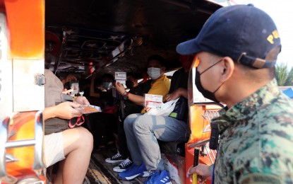 <p><strong>VAX CHECK.</strong> Jeepney passengers show their vaccinataion cards to a police officer at a checkpoint along the Batasan-San Mateo Road on Monday (Jan. 10, 2022). Metro Manila and the neighboring provinces of Rizal, Bulacan, Cavite and Laguna are under Alert Level 3 until January 15 due to soaring coronavirus infections. <em>(PNA photo by Joey O. Razon)</em></p>