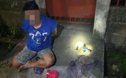 <p><strong>NABBED.</strong> Suspect Arnel Dumahel slumps on the pavement while on handcuffs shortly after getting arrested in Barangay Talungon, Bais City, Negros Oriental on Monday (Jan. 10, 2022) night for violating the Comelec gun ban. He is also facing charges for illegal possession of firearms. <em>(Photo courtesy of the Negros Oriental Provincial Police Office)</em></p>