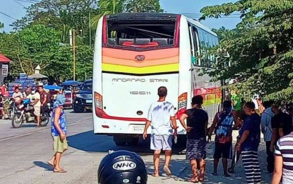 <p><strong>BOMBED BUS</strong>. Civilians gather around a Cotabato City-bound Mindanao Star Bus where an improvised explosive device (IED) went off in Aleosan, North Cotabato at about 8 a.m. Tuesday (Jan. 11, 2022). The IED was placed at the rear portion of the bus and exploded while it was traversing the highway in Barangay San Mateo. <em>(Photo courtesy of Mhen Maslamama/Jess Ali)</em></p>