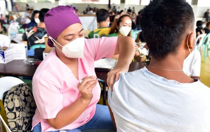 <p><em>VAX JAB. </em>A health worker administers the Covid-19 vaccine to an eligible individual in Dumaguete City, Negros Oriental in this undated photo. The government on Saturday (March 19, 2022) said it has vaccinated 1.8 million individuals belonging to its targeted population during the fourth leg of the national vaccination drive.<em> (File photo from the Lupad Dumaguete Facebook page/City PIO))</em></p>