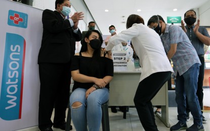 <p><strong>BOOSTERS WITHIN REACH</strong>. A health worker administers an AstraZeneca Covid-19 booster shot to a woman during the launch of the “Resbakuna sa Botika” program at the Watsons SM Center in Pasig City on Thursday (Jan. 20, 2022). The Department of Health said participating pharmacies and clinics would only administer Sinovac and AstraZeneca doses, for now, citing that these vaccine brands do not need special storage requirements.<em> (PNA photo by Joey O. Razon)</em></p>