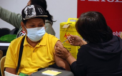 <p><strong>ADDITIONAL PROTECTION.</strong> A senior citizen receives his booster shot of Covid-19 vaccine from a volunteer medical worker at Healthway Manila clinic on Adriatico Street in Ermita on Friday (Jan. 21, 2022). Select branches of private pharmacies and clinics in Metro Manila have been tapped by the government to help ramp up the vaccination rollout. <em>(PNA photo by Jess M. Escaros Jr.)</em></p>
