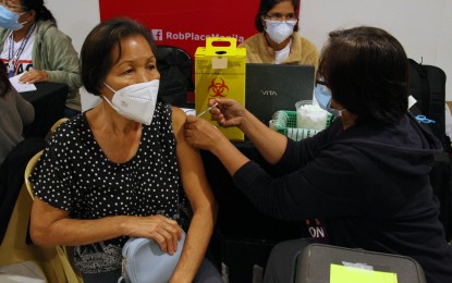 <p><strong>BOOSTED.</strong> A senior citizen receives a booster shot of the Covid-19 vaccine at a Healthway clinic in Ermita, Manila on Friday (Jan. 21, 2022). Private pharmaceutical stores and clinics are helping in the national vaccination rollout by administering booster shots in select branches. <em>(PNA photo by Jess M. Escaros Jr.)</em></p>