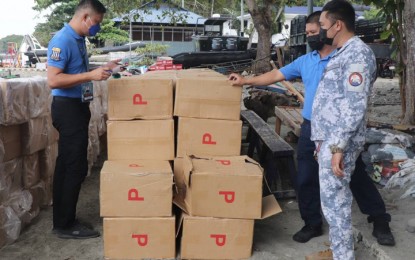 <p><strong>SMUGGLED CIGARETTES.</strong> Personnel of the Bureau of Customs and Naval Forces Western Mindanao (NFWM) conduct a joint inventory of the smuggled cigarettes at the Naval Station Romulo Espaldon in Zamboanga City. Operatives of the NFWM seized the smuggled cigarettes worth PHP9.7 million while on maritime patrol Saturday (Jan. 22, 2022) off Sulade Island in Parang municipality, Sulu. <em>(Photo courtesy of NFWM)</em></p>