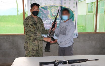 <p><strong>RETURNEE.</strong> Moises Palacio (right), a member the New People's Army - Komiteng Larangang Gerilya operating in the hinterlands of Ilocos and Abra provinces, surrendered with firearms and ammunition to the military in Barangay Aluling, Cervantes, Ilocos Sur on Sunday (Jan. 23, 2022). President Rodrigo Duterte asked rebels to return to the fold of the law and avail of government assistance during the Talk to People Monday night (January 24). <em>(Photo courtesy of Nolcom)</em></p>