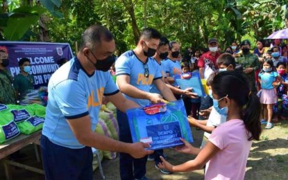 <p><strong>REACHING OUT.</strong> Members of the South Cotabato provincial police office, led by Col. Nathaniel Villegas (left), hand over school supplies to some 200 children in Sitio Lamkugo, Barangay Lansalome, T’boli town on Wednesday (Jan. 26, 2022). The children’s families were also given food packs that contain rice, canned goods, and other grocery items during the outreach program. <em>(Photo courtesy of SCPPO)</em></p>