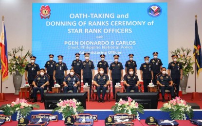 <p><strong>PROMOTED.</strong> PNP chief, Gen. Dionardo Carlos (seated, center) poses with 14 senior police officials who were promoted to the next higher rank during short ceremonies in Camp Crame, Quezon City on Wednesday (Jan. 26, 2022). Carlos called on the newly promoted officials to focus on building integrity and credibility as true public servants. <em>(Photo courtesy of PNP)</em></p>