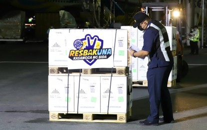 <p><strong>CUSTOMS CHECK.</strong> A Bureau of Customs personnel inspects the boxes containing the newly delivered Pfizer Covid-19 vaccine shortly after it arrives at the Ninoy Aquino International Airport Terminal 3 in Pasay City on Wednesday (Feb. 2, 2022) night. The latest vaccine delivery, a total of 455,130 doses, is procured by the national government.<em> (PNA photo by Robert Oswald P. Alfiler)</em></p>