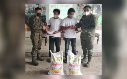 <p><strong>FATHER AND SON.</strong> A father and son members of the Abu Sayyaf Group (ASG) receive food and cash assistance after surrendering to the troops of the 1103rd Infantry Brigade Thursday (Feb. 3, 2022) in Barangay Bonbon, Patikul, Sulu. The two will be enrolled in the Localized Social Integration Program of the provincial government of Sulu. <em>(Photo courtesy of Western Mindanao Command Public Information Office)</em></p>