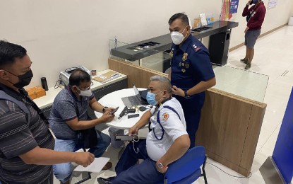 <p><strong>DUE RECOGNITION.</strong> Peter Lagrosas (center, sitting), a bank security guard, voluntarily submits himself to be questioned by police authorities for shooting an alleged scammer on February 4 in Cagayan de Oro City. Lagrosas was given an award Tuesday (Feb. 8, 2022) for responding to the distress call of two victims of the alleged scammer. <em>(Photo courtesy of COCPO)</em></p>