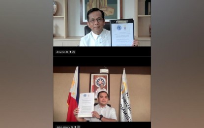 <p><strong>DIGITAL ECONOMY.</strong> Philippine Competition Commission (PCC) chairperson Arsenio Balisacan and National Privacy Commission (NPC) chairperson and Commissioner John Henry Naga (top to bottom) show copies of the memorandum of agreement between the PCC and NPC during the virtual ceremonial signing on Feb. 9, 2022. The two agencies have forged a partnership to boost cooperation in addressing anti-competitive behavior and data privacy issues amid the growing digital economy.<em> (Photo courtesy of PCC)</em></p>